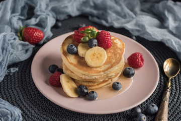 Delicious american pancakes with berries, banana and syrup. Horizontal