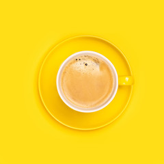 Yellow coffee cup on yellow background, flat lay
