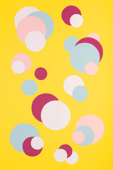 Colorful paper circles on yellow paper background