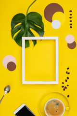 Creative flat lay with cup of coffee and tropical plant