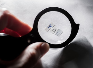 finding yourself. Word "you" of letters on paper through a magnifying glass