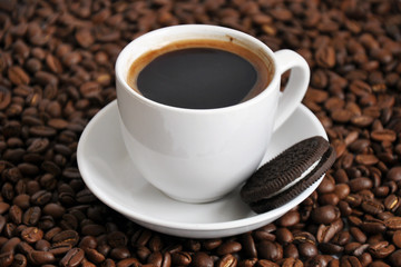 cup of coffee and cookie with beans background