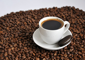 cup of coffee and cookie with beans background