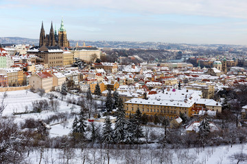 Obraz premium Snowy Prague City with gothic Castle from Hill Petrin in the sunny Day, Czech republic