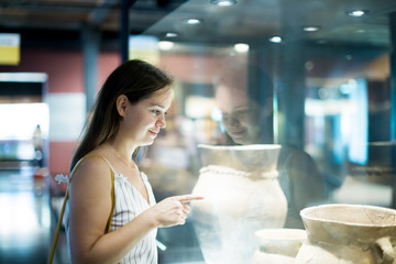 beautiful girl considers exhibits in museum