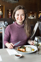 Woman sitting in restaurant and having tasty lunch