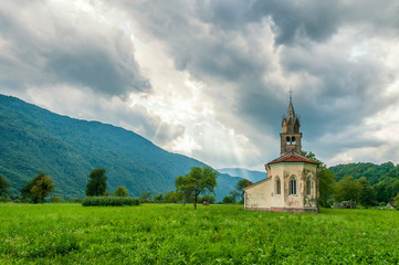 Old church with dramatic sky with sun rays