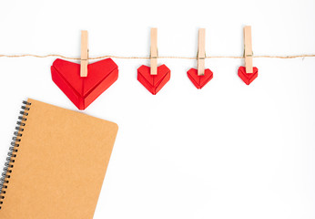 top view Notebook,Red heart folded with paper origami hearts showing love for Valentine's Day Isolated on White Background There is space for entering text.