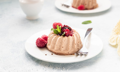 Mini chocolate cheesecake with raspberry sauce and mint. No crust cheesecake. Diet dessert. Light grey stone concrete background. Top view. Copy space.