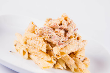 Pasta - penne with cream sauce with bacon on a plate