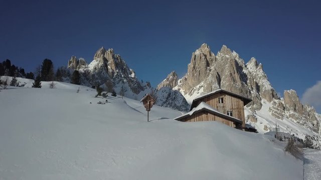 Winter sunny day in Dolomites, with much snow, peaceful place in the Cadini di Misurina area, near the Rifugio Citt&radic;&dagger; di Carpi, with sledding people on the snowy road.