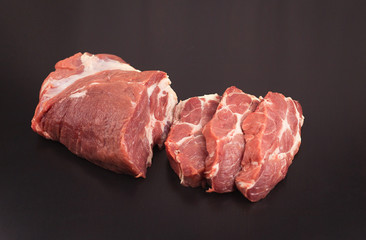 Fresh pork steaks on black wooden background
