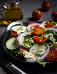 Fresh green salad with blue cheese, onions and cherry tomatoes