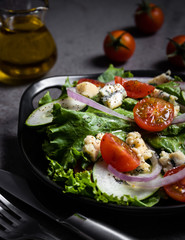 Fresh green salad with blue cheese, onions and cherry tomatoes