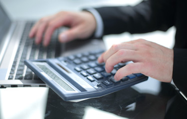 Close-up Of A Businessperson's Hand Using Calculator