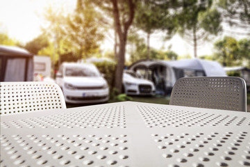 White metal table with two chairs and free space for your decoration. Summer background of camping.