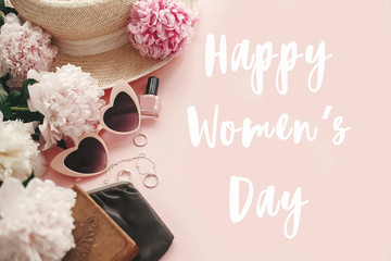 Happy Women's Day text sign at stylish girly pink retro sunglasses,peonies, jewelry, hat, purse,cosmetics on pastel pink paper flat lay. Girl Power. International womens day, 8 march