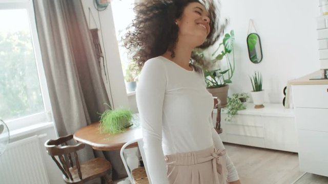 Portrait of cheerful woman dancing at home.