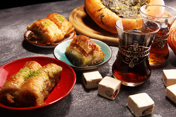 Middle eastern or arabic dishes and assorted meze, concrete rustic background. sambusak. Turkish Dessert Baklava with pistachio. Halal food.