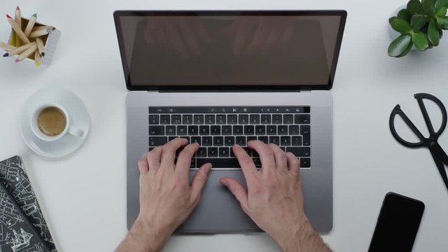 Male hands typing laptop on white clean minimalistic table with top view, gestures and finger movements
