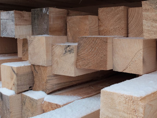 Piled lumber in the outdoor warehouse in the winter