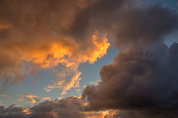 Dense orange and storm clouds at sunset in the sky