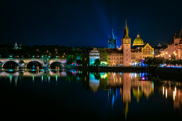 Fototapeta na wymiar praga vistas nocturnas con reflejos en el rio moldava charles bridge