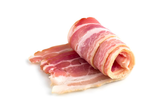Slices of bacon on a white background. Raw rolled bacon on a white background.