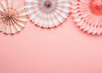 Chinese paper fans in pastel colors on pink table, top view, copy space for text, selective focus