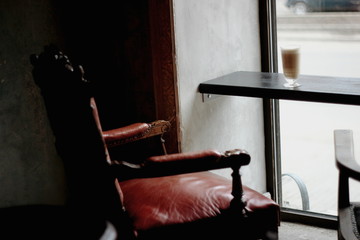 retro armchair in the interior near the window and a glass of latte coffee