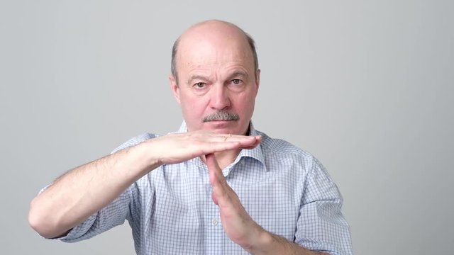 Senior man giving showing time out hands gesture