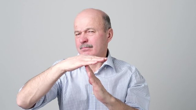 Senior man giving showing time out hands gesture