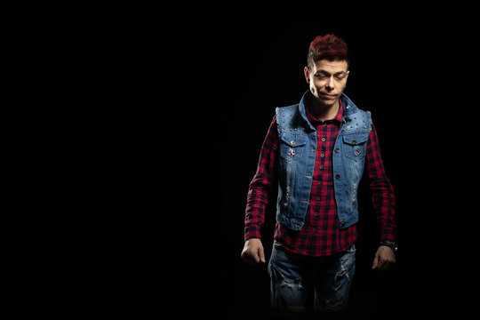 Woman with red hair in a denim suit posing on a black background