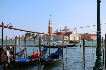 Fototapeta na wymiar Gondolas on Riva degli Schiavoni, promenade in Venice, Italy. View of San Giorgio Maggiore church and island in the background.