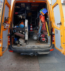 Cargo space of a construction vehicle, loaded with various tools, transport cart, barriers, shovels...