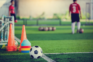 Obraz premium soccer ball and soccer training equipment on green artificial turf
