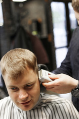 man in barbershop making a new hairdresser with barber 