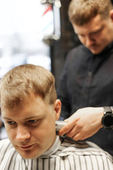Fototapeta premium man in barbershop making a new hairdresser with barber 