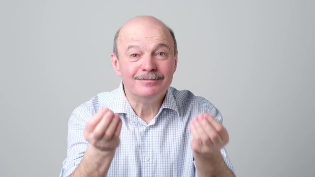 Mature handsome man showing italian gesture that means what do you want