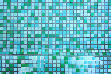 Mixed blue colored square tile mosaic background underwater in a swimming pool