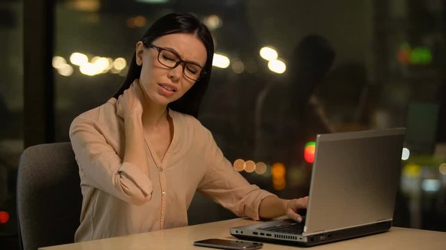Woman suffering neck pain after working on laptop for long period, muscle strain