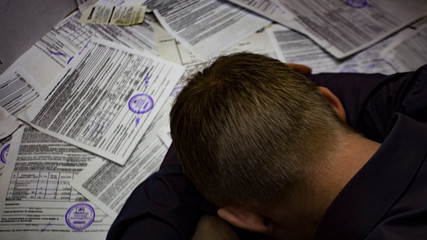 A man with receipts and invoices.Crisis, slump.Insolvent debt obligations on loans among the...