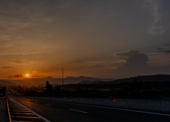 Fototapeta na wymiar SUNSET IN A HIGHWAY AND SKY WITH CLOUDS
