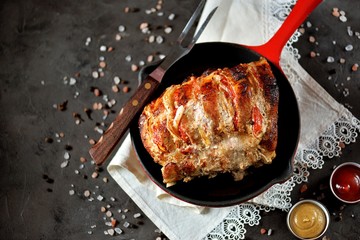 Pork baked with onions and tomatoes in a cast iron pan.