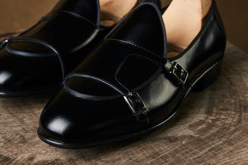 Tie and a Pair of man's classic leather shoes on wooden stump