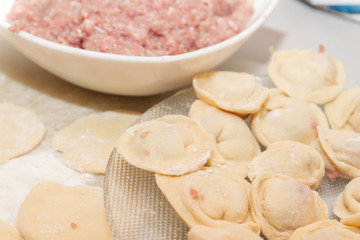 Raw and fresh dumplings lie on a glass plate