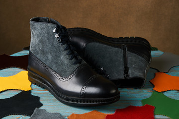 Shoe making concept with mens boots over brown background