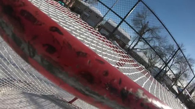 Hockey Puck hits the cross bar of the net on an outdoor rink