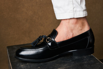 Close-up legs of businessman walking stepping up stair over brown background