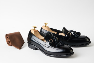 Elegant mens leather shoes and necktie isolated on white background